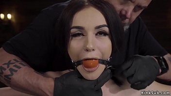 Gagged brunette slave Rosalyn Sphinx in standing device bondage drooling over her small tits with clamped nipples then electro shocked and rubbed